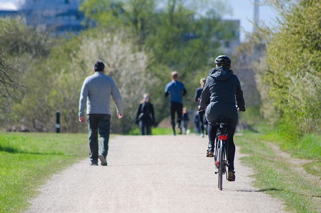 des adultes marchent, courent et pratiquent le vélo dans un parc urbain